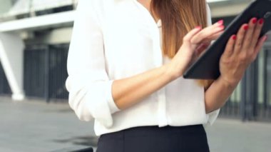 İş kadını ayakta, tablet bilgisayar tutarak çalışma. Gülümseyen.