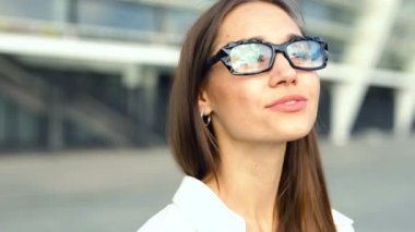 Mutlu, gülümseyen kadın portresi. Cityscape gözlüklü yansıması.