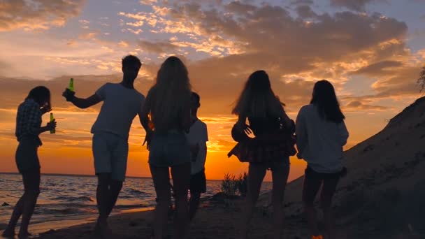 Vänner Dansa Stranden Vid Solnedgången Holding Gröna Flaskor Slow Motion — Stockvideo