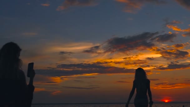 Dos Chicas Tomando Fotos Playa Tiempo Puesta Del Sol — Vídeo de stock