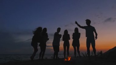 Arkadaşlar kumsal partisi bitirme grup. Adam titreyen bira şişesi.