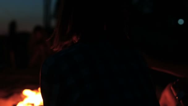Gros plan du couple assis près du feu de camp. Ferme là. Vue de dos .