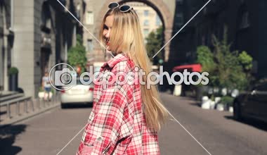 Genç, mutlu, gülümseyen sarışın kadın street yürüyüş. İşi bana hareketini izleyin.