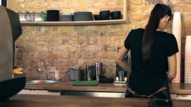 Kadın barista kahve fincan müşteriye vererek ve ona hoş geldin. Sabit cam dükkanı. Stabilize.