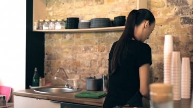 Kahve dükkanında çalışan garson. Arkadan görüntüleyin. Steadycam atış.