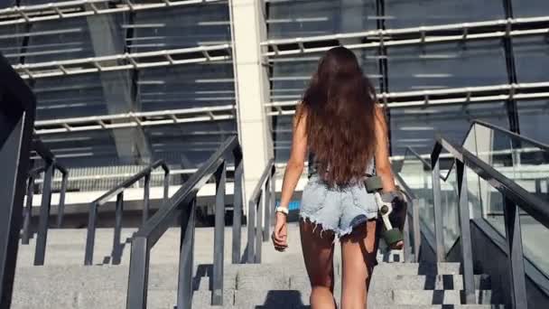 スポーティな若い女性ロングボードを押し歩いて階段を上る バックからの眺め — ストック動画