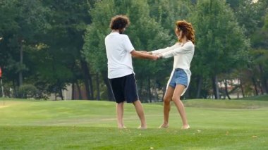 Mutlu çift el ele tutuşarak aşk ve çevresinde whirl. Yaz saati, parkta hafta sonu. Slowmotion.
