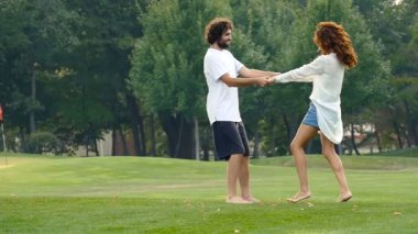 Mutlu çift güzel yaz günü şehir parkında tadını seviyorum. Tutan eller ve koşuşturma. Slowmotion.