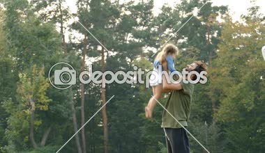 Babası şehir parkı açık havada küçük kızı ile oynarken. Slowmotion.