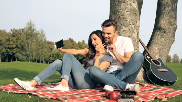 Feliz Pareja Moderna Sentada Cuadros Cerca Del Árbol Tomar Selfies — Vídeo de stock