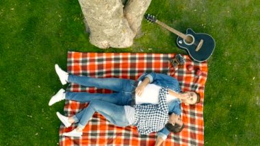 Parkta ekose yatan bir kaç. Sarılma ve eğleniyor. Üstten görünüm çekim.