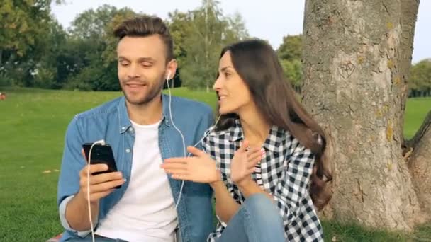 Koppel Het Weekend Het Park Luisteren Naar Muziek Smartphones Een — Stockvideo