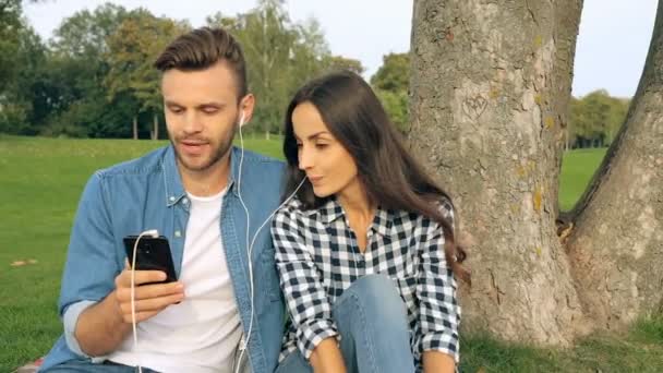 Unga Paret Sitter Nära Trädet Parken Man Hålla Smartphone Och — Stockvideo