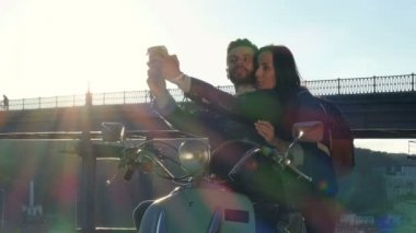 Çift scooter üzerinde oturan ve selfies anlık görüntü kameraya alıyor.