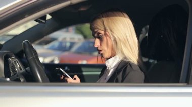 Stresli, mutsuz sarışın kadın arabada otururken, Evet ve bunu atma.