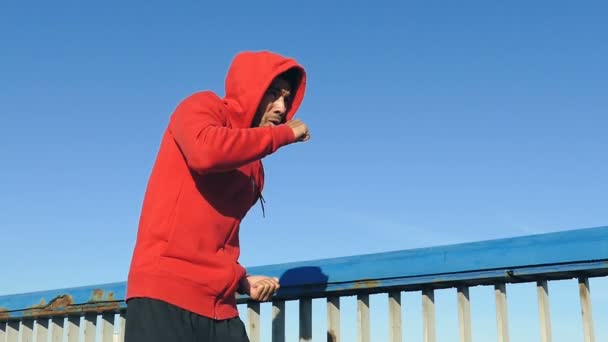 Hombre Con Capucha Roja Entrenando Boxeando Aire Libre Puente Lento — Vídeo de stock