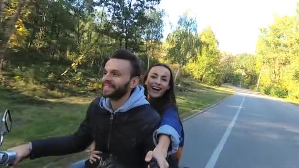 骑在摩托车上并在动作片上拍摄视频的年轻夫妇 — 图库视频影像