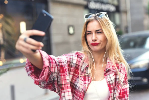 Selfies üstünde smartphone alarak komik sarışın kadın.