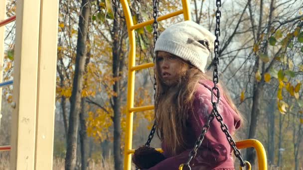 在操场上沮丧的无家可归的女孩 和泰迪熊坐在秋千上 慢速运动 — 图库视频影像
