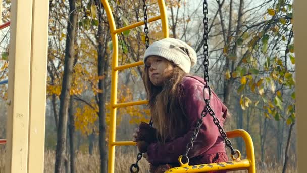 无家可归的小女孩坐在秋千上 抱着泰迪熊 慢速运动 — 图库视频影像