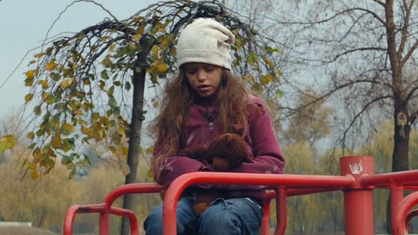 Menina Sem Teto Segurando Ursinho Pelúcia Girando Playground — Vídeo de Stock