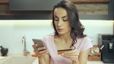 Smartphone ve kredi kartı tutan genç kadın. Online ödeme yapıyor.