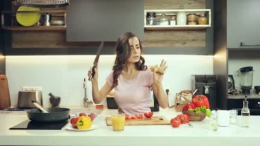 Çekici kadın iyi ruh hali eğleniyor. Dinlerken müzik ve pişirme sırasında çılgın dans.