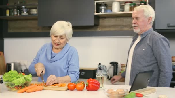 Betagtes Ehepaar Mann Scherzt Und Nimmt Zuckerbrot Während Frau Salatgericht — Stockvideo