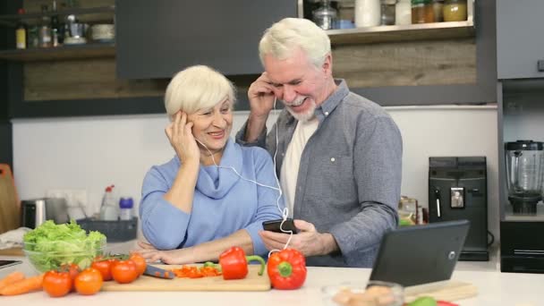 Glückliches Älteres Ehepaar Der Küche Musik Über Kopfhörer Hören — Stockvideo