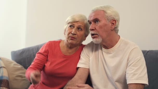 Elder Couple Sitting Sofa Watching Discussing News — Stock Video