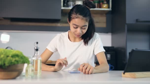 Jovem Mulher Digitando Deslizando Tela Smartphone Cozinha — Vídeo de Stock