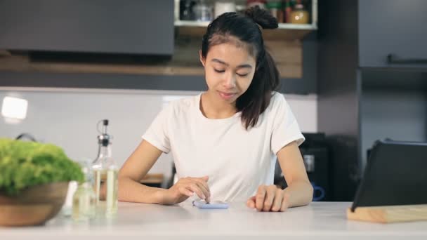 Uma Jovem Cozinha Sentado Mensagens Texto Smartphone — Vídeo de Stock