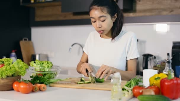 年轻女子切黄瓜和测试它 在厨房准备沙拉菜 — 图库视频影像