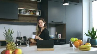 Genç kadın mutfakta kahve içme. Dijital tablet vasıl arıyorum. Günaydın.