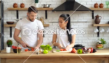 Mutfakta genç bir çift. Sebze kesme, birlikte salata çanak hazırlamak.
