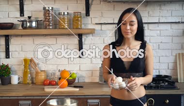 Genç kadın yemek pişiriyor. Yumurta yoğurma ve hamur hazırlama.