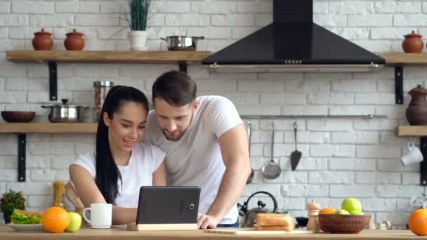 Casal Cozinha Olhando Para Comprimido Difital Juntos Pesquisa Web — Vídeo de Stock