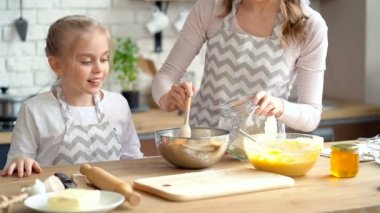 Anne kızı birlikte yemek. Plakasına un dökme anne. Ona bakarken kızı.