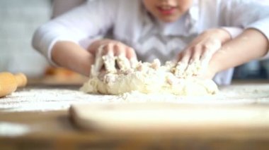 Yakın çekim. Anne ve kızı hamur yoğurma elleri. Elleri ve hamur üzerinde odaklanmak.