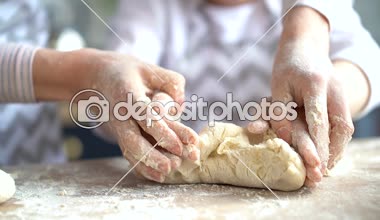 Yakın çekim. Anne ve küçük kızı hamur yoğurma elleri. Pişirme öğretim kız anne.