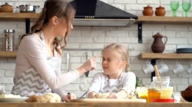 Anne ve kızı mutfakta un ile eğleniyor. 