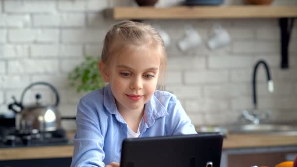 Nettes Kleines Mädchen Das Der Küche Auf Das Tablet Schaut — Stockvideo