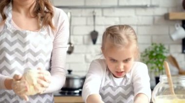 Anne ve kızı eğleniyor. Hamur yoğurma.
