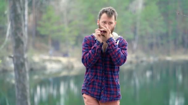 Mann Steht See Und Spielt Auf Der Mundharmonika — Stockvideo