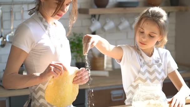 两个妹妹 或母亲女儿 在厨房准备蛋糕 女孩倒在桌子上的面粉 — 图库视频影像