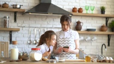 Akıllı telefon ve cheking malzemelerde tarifi görünümlü iki kız kardeş.