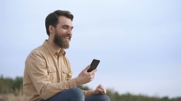 Portret Przystojnego Broda Człowieka Zewnątrz Trzymając Smartfon Zobaczyć Dobre Wiadomości — Wideo stockowe