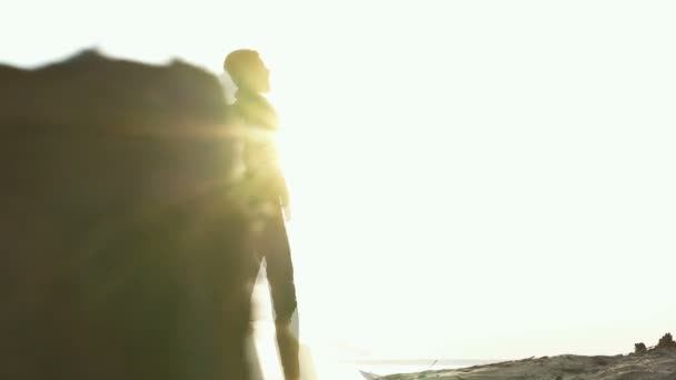 背着背包的成年男子站在户外 看着大海和日落 稳定摄像头拍摄 — 图库视频影像