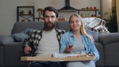 Evde TV izlerken mutlu genç çift.