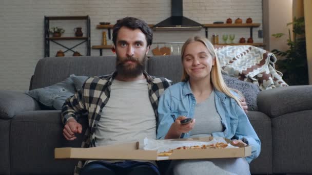 家でテレビを見て幸せな若いカップル — ストック動画